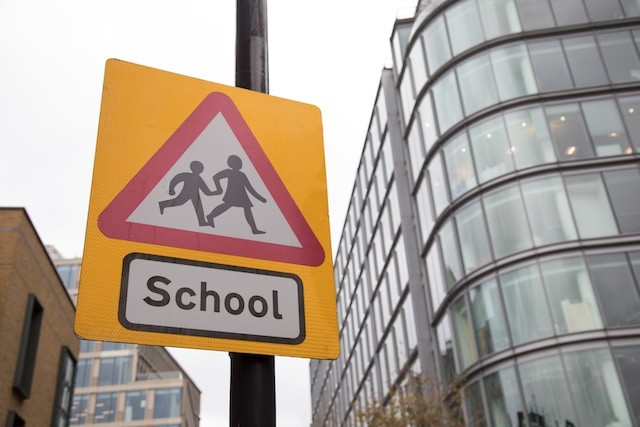 a school crossing sign in front of a building