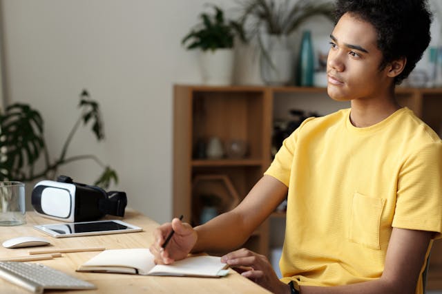 boy-in-yellow-crew-neck-t-shirt-writing-on-white-paper